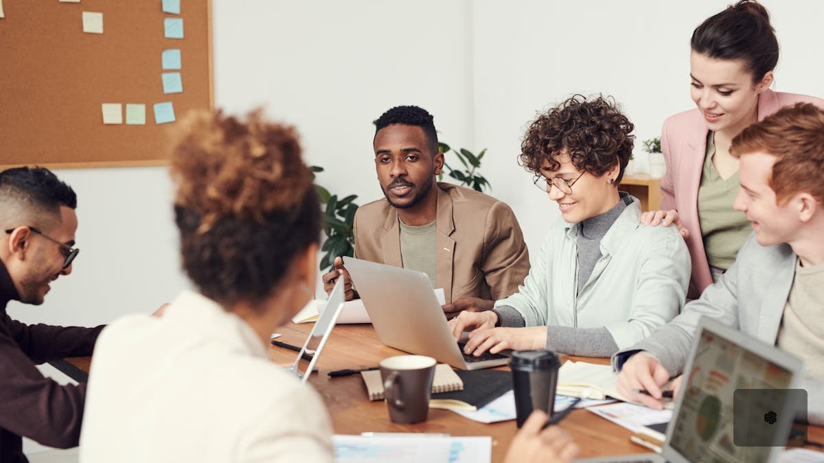 Project manager pointing to whiteboard workflow diagram while team members review automation priority list on tablets around a modern conference table